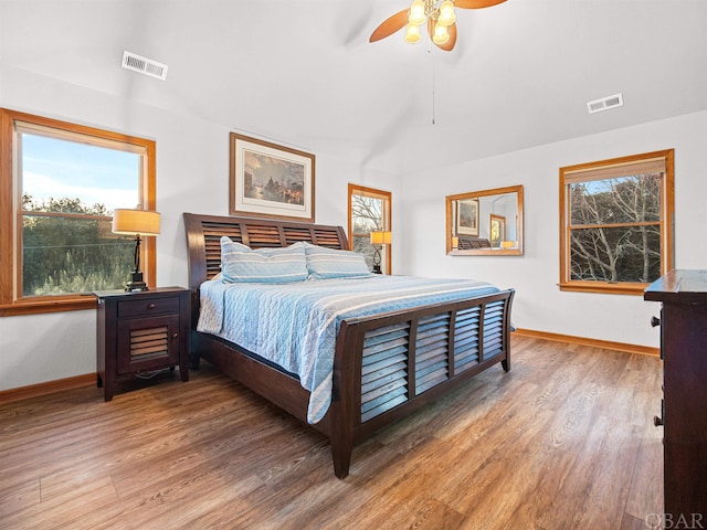 bedroom featuring baseboards, visible vents, and wood finished floors