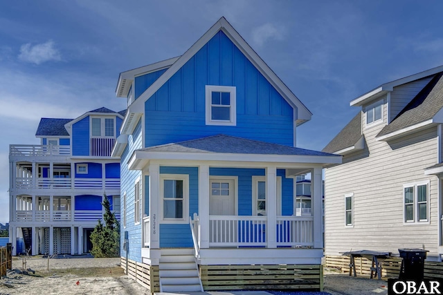 view of front of home with board and batten siding, covered porch, and a shingled roof