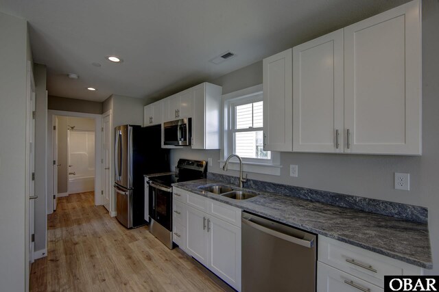 27250 Sand St Lot # 7, Salvo, NC 27972 - kitchen featuring appliances with stainless steel finishes, a sink, white cabinets, light wood-style floors, and a ceiling fan