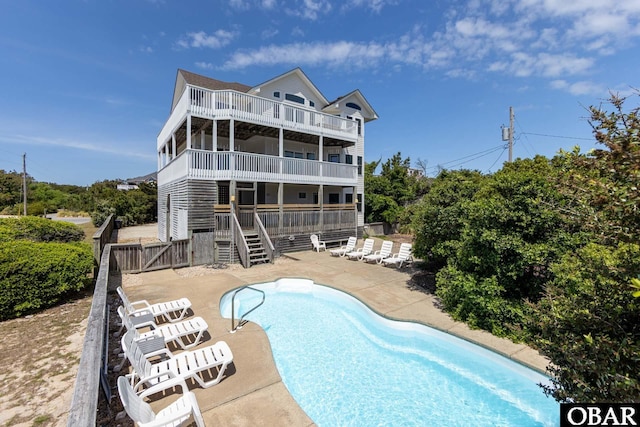 25245 Island Pines Dr Lot 6, Waves, NC 27982 - rear view of property featuring a patio, a balcony, fence private yard, an outdoor pool, and stairs