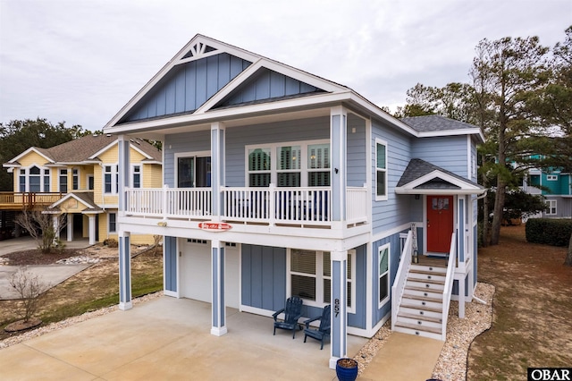 view of front of property featuring driveway, a porch, board and batten siding, and a shingled roof