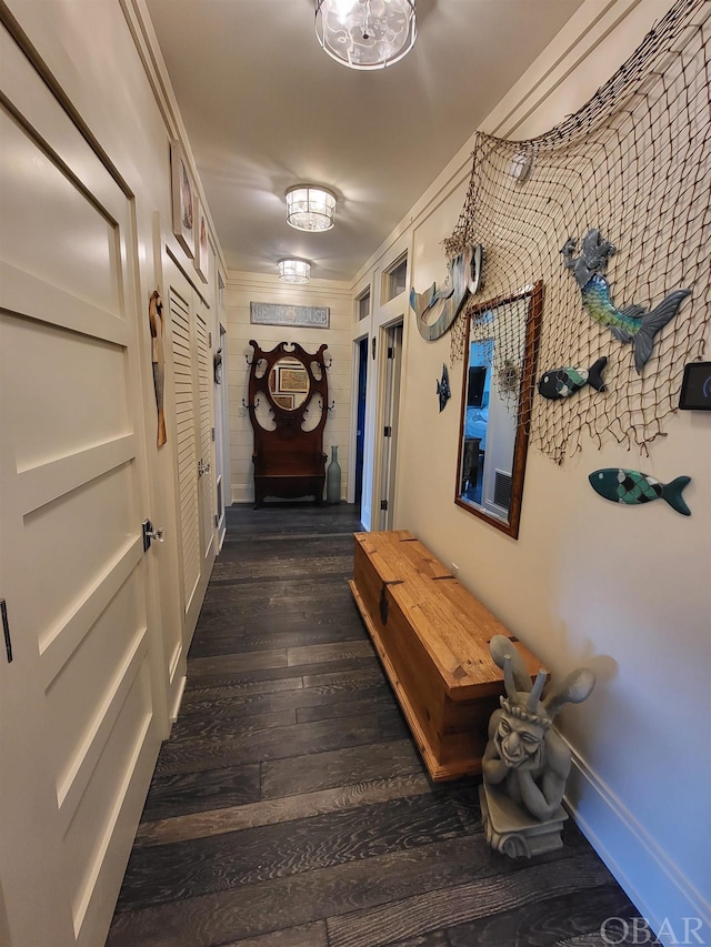 hall with dark wood-style flooring and baseboards