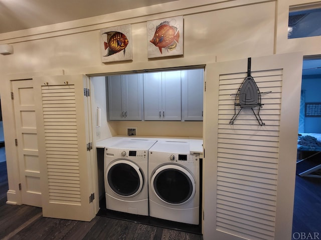 laundry room featuring dark wood finished floors, cabinet space, and washer and dryer