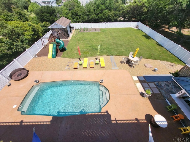 view of pool with an outdoor fire pit, a playground, a lawn, and a fenced backyard