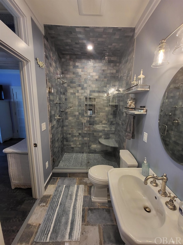 full bathroom featuring visible vents, a sink, a shower stall, and toilet