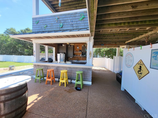 view of patio featuring fence and outdoor dry bar