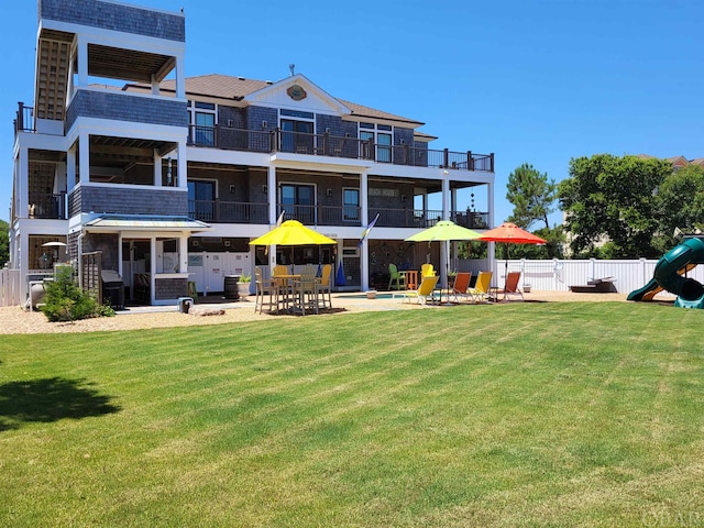 back of house featuring playground community, a patio, fence, and a lawn