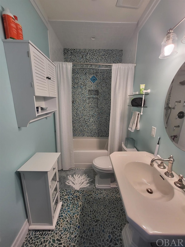 bathroom with shower / bath combo, a sink, and toilet