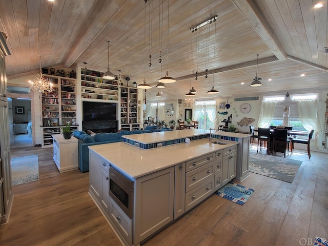 kitchen featuring a large island, open floor plan, light countertops, and decorative light fixtures