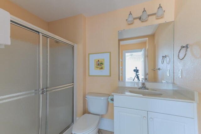 bathroom featuring a stall shower, vanity, and toilet