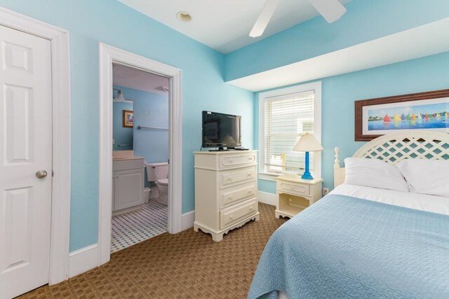 bedroom featuring ensuite bathroom, ceiling fan, light colored carpet, and baseboards