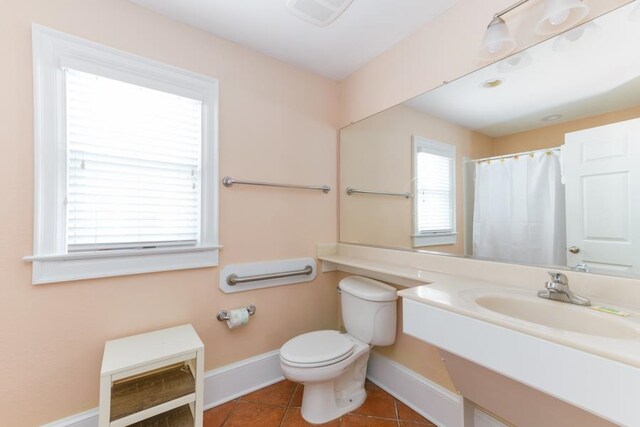 bathroom featuring toilet, tile patterned flooring, baseboards, and a sink