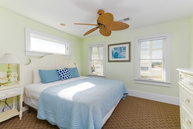 bedroom featuring a ceiling fan, dark colored carpet, visible vents, and baseboards