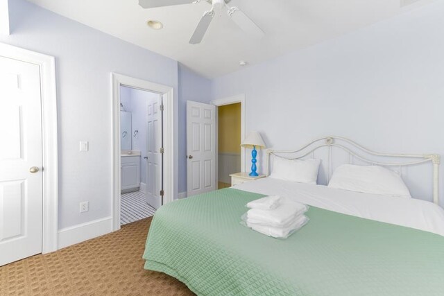 bedroom featuring carpet floors, connected bathroom, baseboards, and ceiling fan