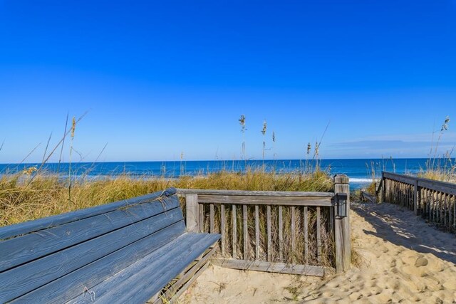 surrounding community with a beach view and a water view