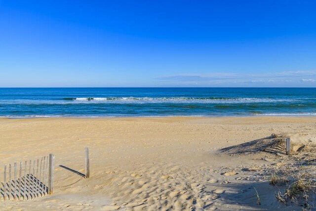 water view with fence and a beach view