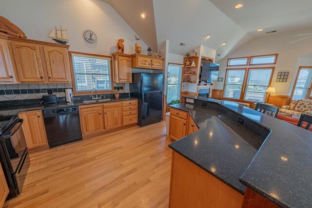 kitchen featuring black appliances, high vaulted ceiling, light wood-type flooring, and a sink