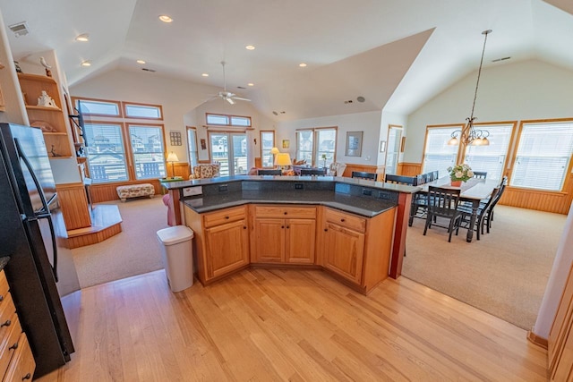 kitchen featuring visible vents, light wood-style floors, open floor plan, hanging light fixtures, and freestanding refrigerator