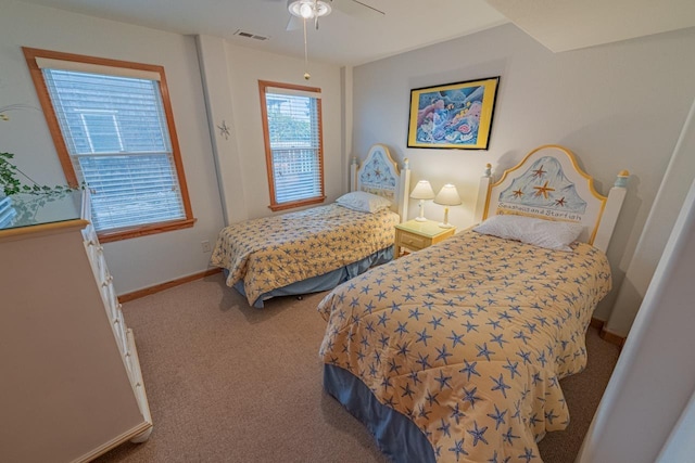 carpeted bedroom featuring a ceiling fan, visible vents, and baseboards