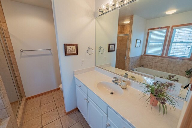 full bathroom featuring toilet, a stall shower, vanity, tile patterned flooring, and baseboards