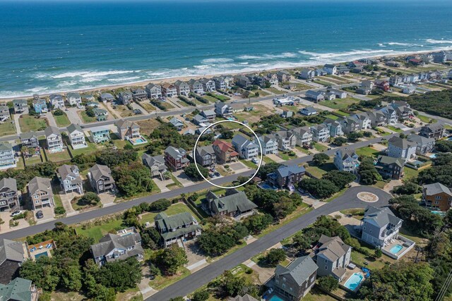 drone / aerial view with a water view, a residential view, and a beach view