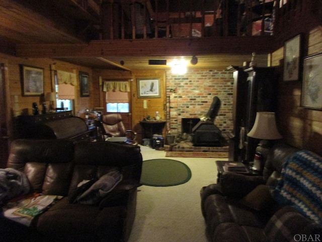 living room with a wood stove, wooden walls, and carpet flooring