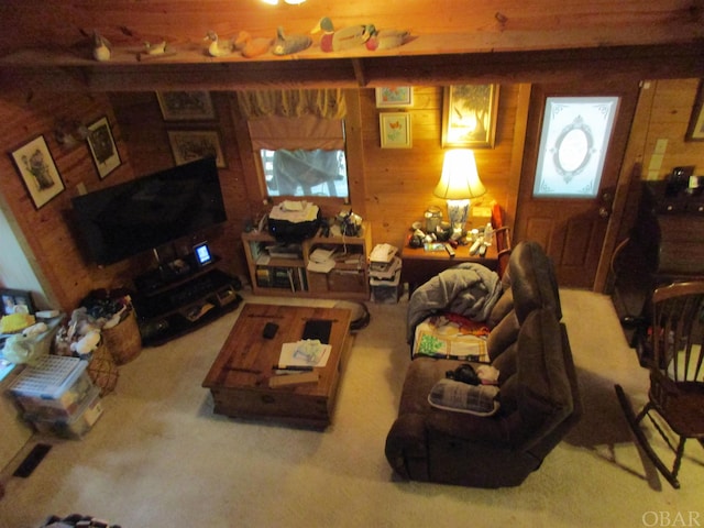 carpeted living room featuring wooden walls