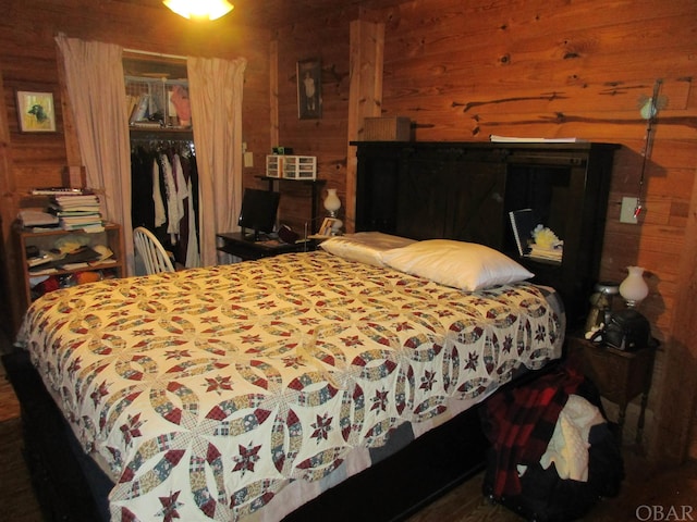 bedroom with a closet and wood walls