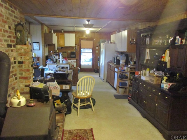 kitchen with freestanding refrigerator, wooden ceiling, light colored carpet, and dark brown cabinetry