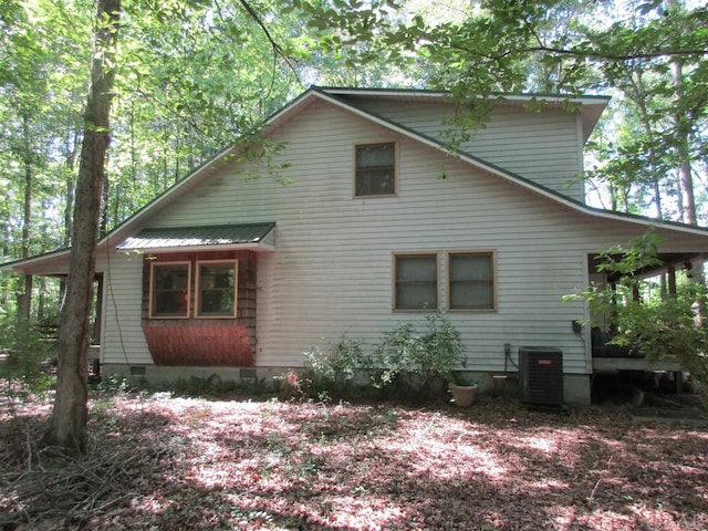 exterior space featuring crawl space, metal roof, and cooling unit