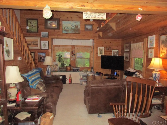 living room with wooden walls, stairs, and beamed ceiling