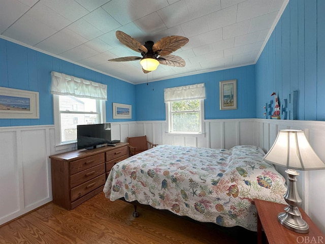 bedroom with a ceiling fan, crown molding, and wood finished floors