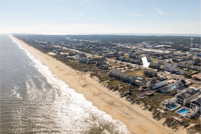 birds eye view of property with a water view and a beach view