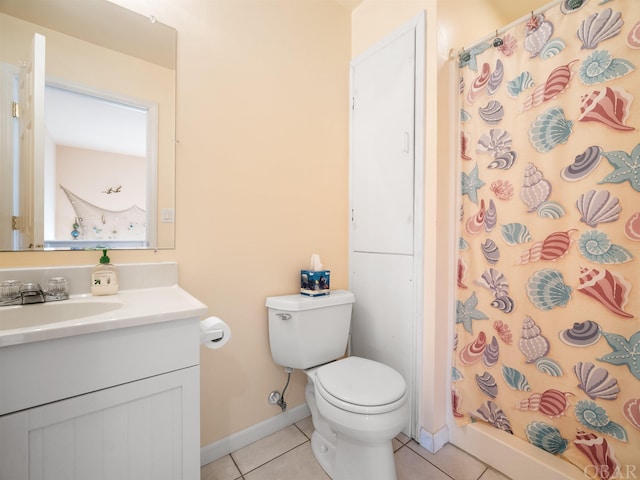 bathroom featuring tile patterned flooring, toilet, vanity, baseboards, and a stall shower