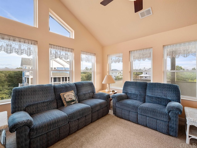 living area with ceiling fan, a wealth of natural light, carpet, and visible vents