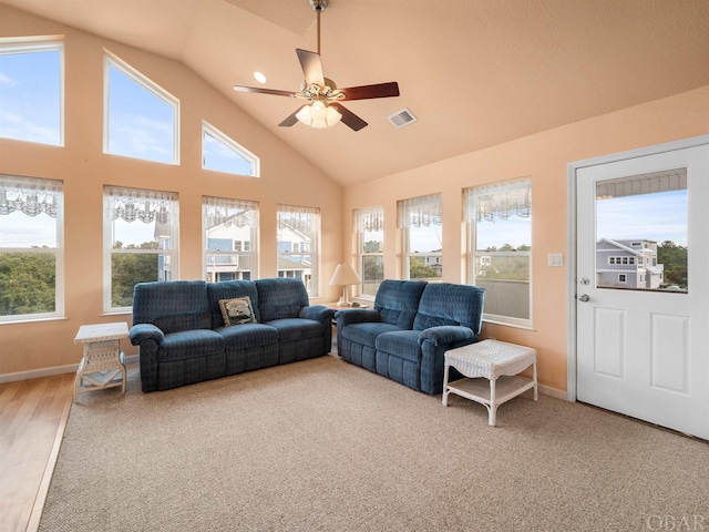 living room with high vaulted ceiling, ceiling fan, visible vents, and a wealth of natural light