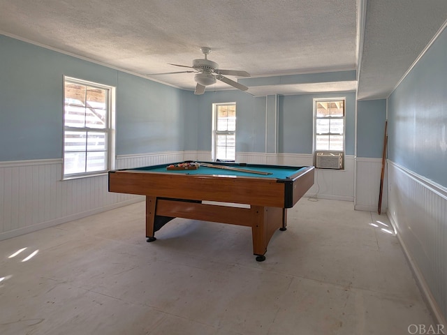 playroom with wainscoting, ceiling fan, a textured ceiling, concrete flooring, and billiards