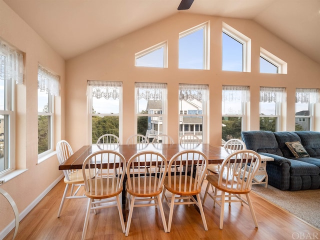 dining room with lofted ceiling, light wood finished floors, and baseboards