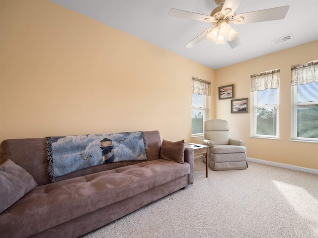 living room featuring carpet floors, baseboards, visible vents, and a ceiling fan