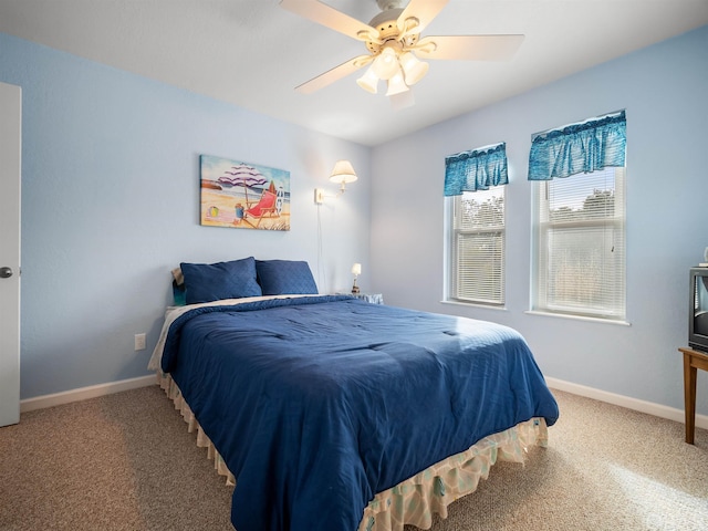 carpeted bedroom featuring baseboards and a ceiling fan