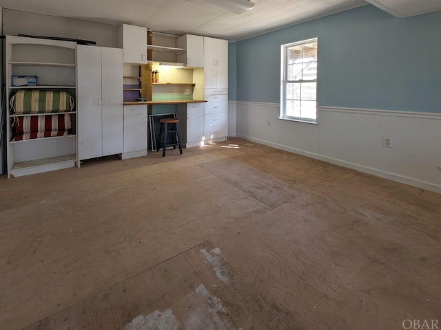 unfurnished living room with wainscoting