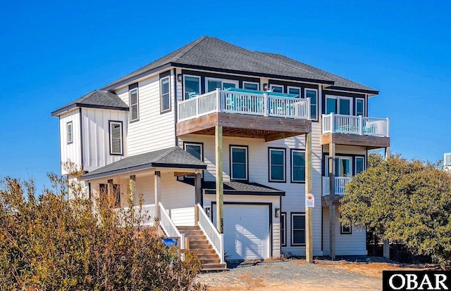 view of front of house featuring board and batten siding, a shingled roof, a balcony, and a garage