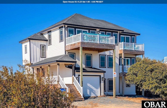 view of front of house featuring board and batten siding, a shingled roof, gravel driveway, stairs, and a garage