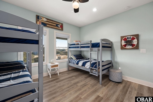 bedroom featuring a ceiling fan, wood finished floors, and baseboards