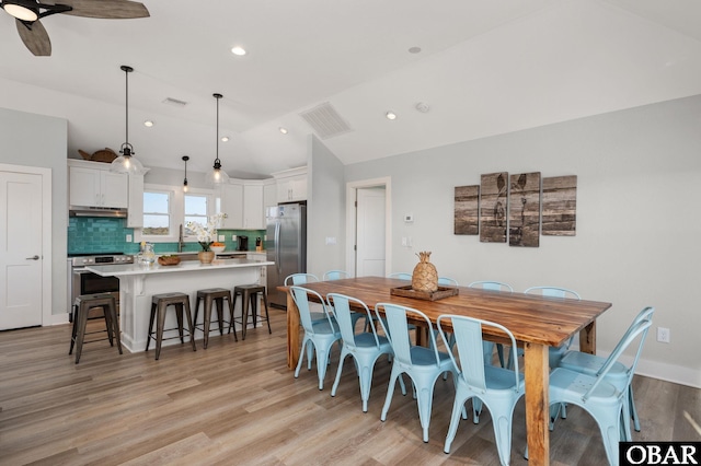 dining room featuring recessed lighting, visible vents, light wood-style floors, and vaulted ceiling