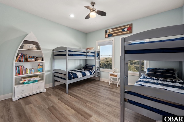 bedroom featuring wood finished floors, baseboards, and ceiling fan