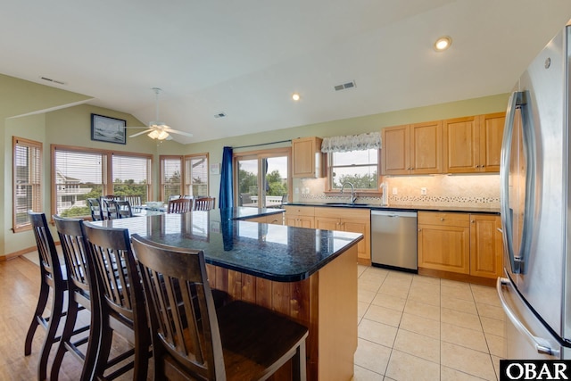 117 Four Seasons Ln Lot 12, Duck, NC 27949 - kitchen featuring appliances with stainless steel finishes, lofted ceiling, a ceiling fan, a breakfast bar area, and decorative backsplash