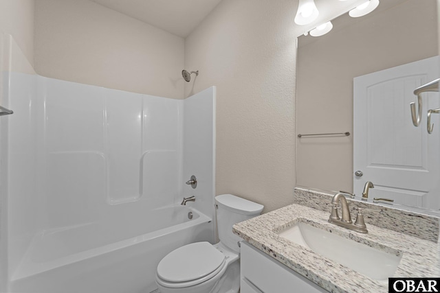 full bathroom featuring washtub / shower combination, a textured wall, toilet, and vanity