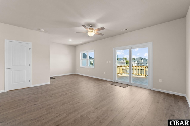 unfurnished room with a ceiling fan, baseboards, and wood finished floors