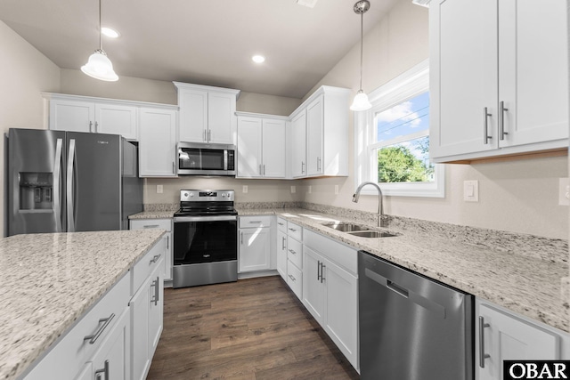 kitchen featuring dark wood finished floors, decorative light fixtures, stainless steel appliances, white cabinetry, and a sink